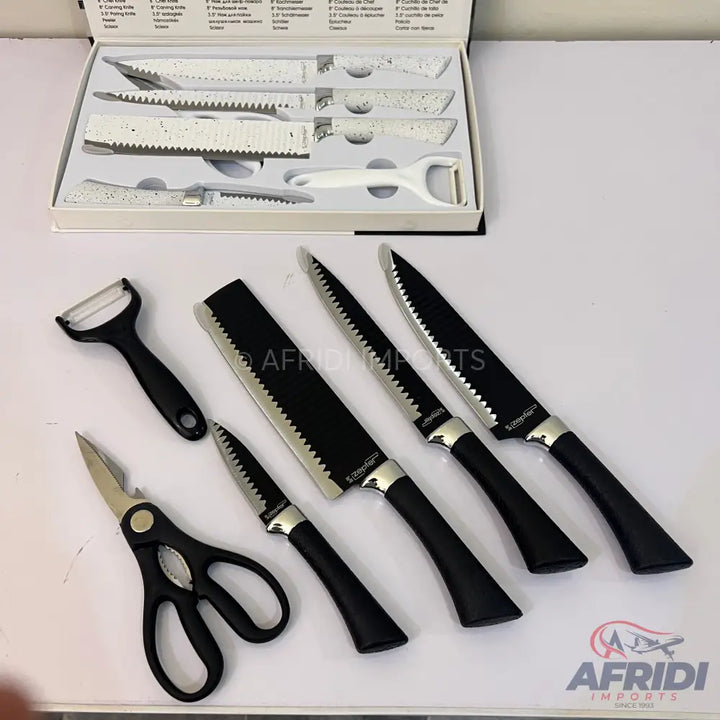 A set of kitchen knives, a peeler, and kitchen shears with black handles.