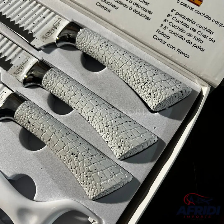A set of three kitchen knives with white, textured handles and metallic bolsters, displayed in a fitted box.